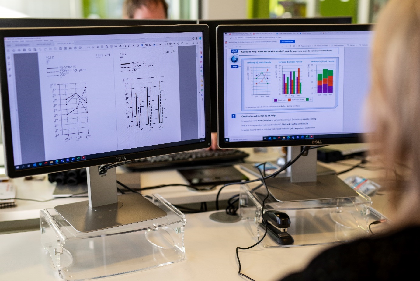 Twee computerschermen naast elkaar. Op de ene is een pagina met grafieken in een schoolboek te zien, op de andere de vereenvoudigde versies van de grafieken voor de voelbare tekeningen.