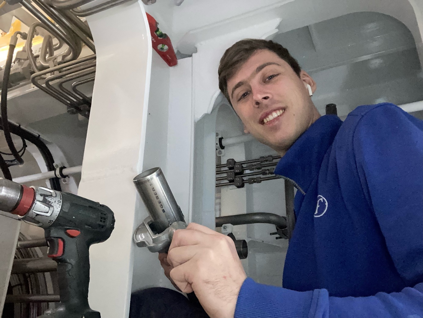 Robin Bouwmans tijdens zijn werk als loodgieter, met koptelefoontjes in.